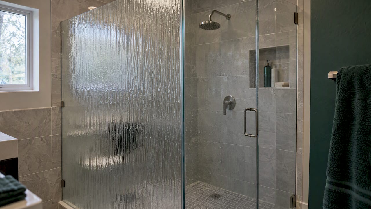 Patterned safety glass in a shower enclosure